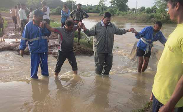 Villagers form human chain to navigate strong current in flooded area