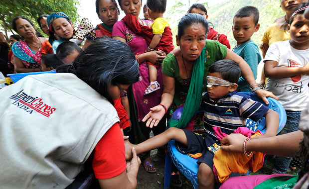 Dr. Swati Jha of AmeriCares India treats a 7-year-old earthquake survivor’s infected wounds during a medical camp in Arughat, in Gorkha District. 